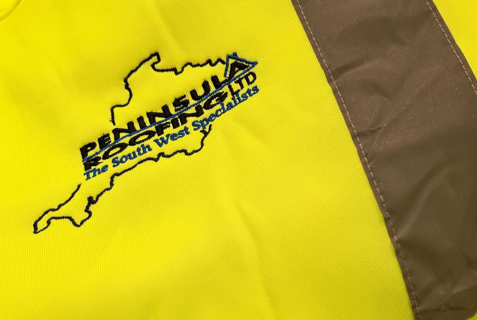 Yellow hi-vis jacket with a reflective stripe, embroidered with the Peninsula Roofing Ltd logo